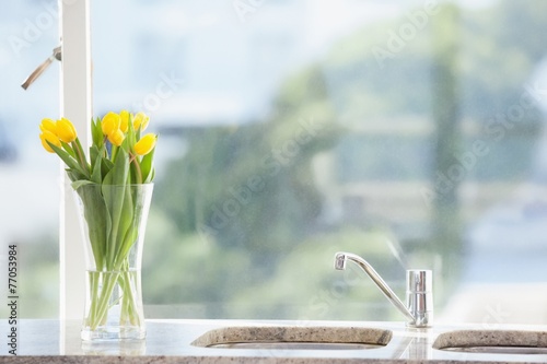 Fototapeta Naklejka Na Ścianę i Meble -  Yellow flower in a vase on the sink