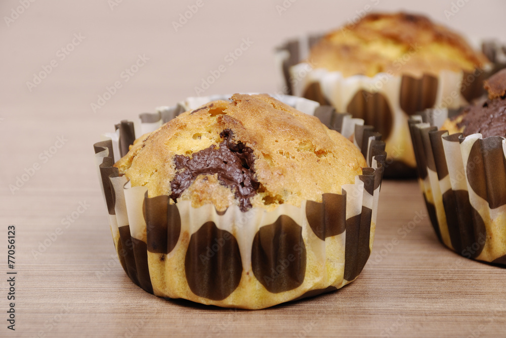Homemade cupcakes with chocolate on a wooden table