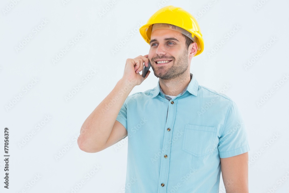 Happy male architect conversing on mobile phone