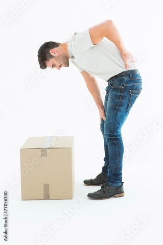 Side view of delivery man suffering from back pain