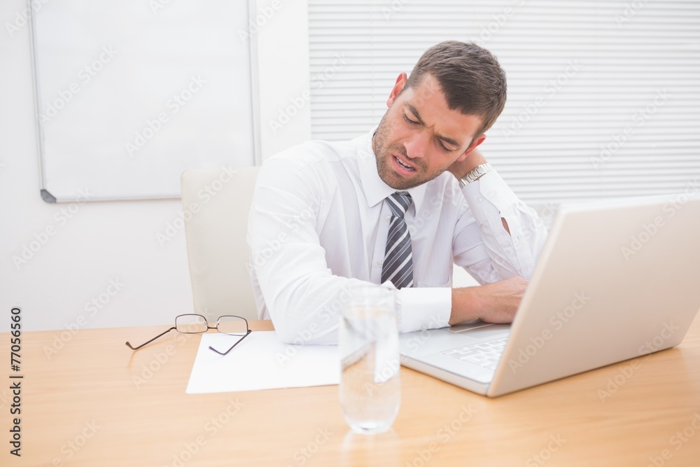 Confused businessman looking at his laptop