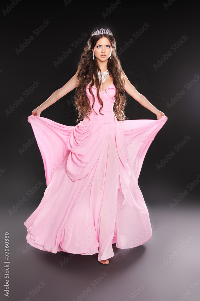 Beautiful young woman in pink chiffon dress with blowing skirt o Beautiful young woman in pink chiffon dress with blowing skirt o