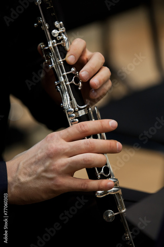 Human hands playing a clarinet closeup