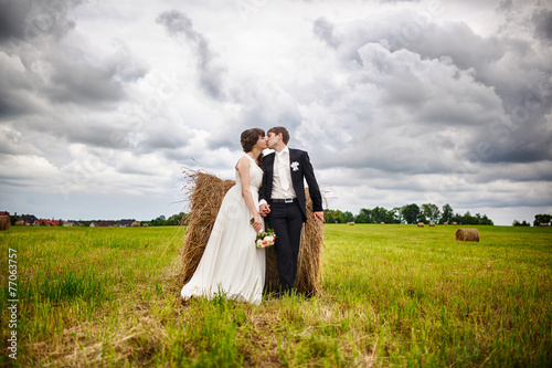 Bride and groom near hay