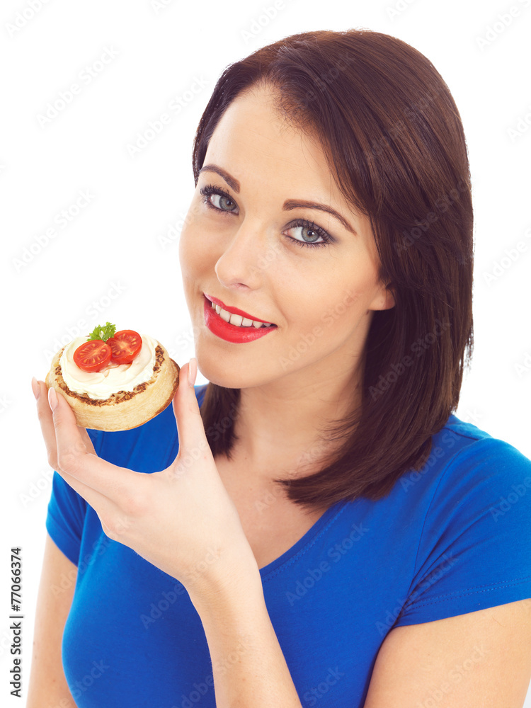 Young Woman Eating Toasted Crumpet with Cream Cheese and Tomato Young Woman Eating Toasted Crumpet with Cream Cheese and Tomato