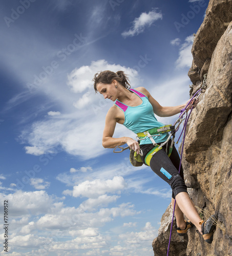 Fotografija Female rock climber hanging over the abyss