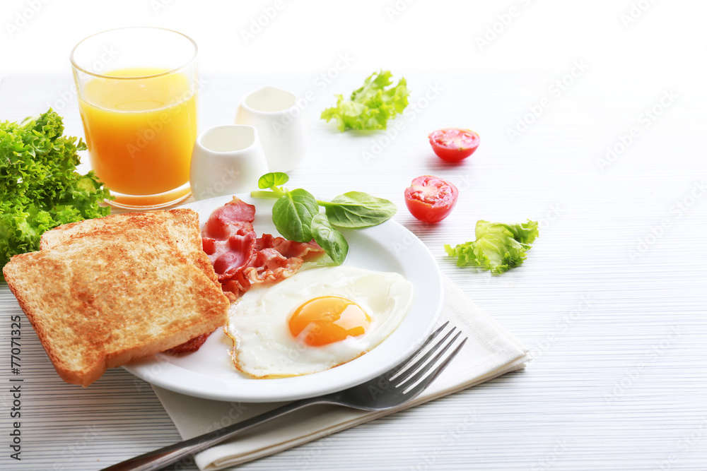 Bacon and eggs on color wooden table and white background Bacon and eggs on color wooden table and white background