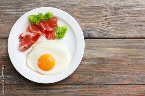 Bacon and eggs on rustic wooden planks background