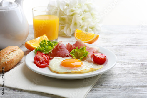 Bacon and eggs on wooden table and white background