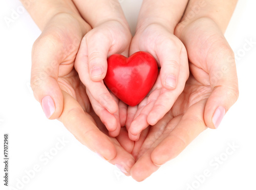 Heart in child and mother hands isolated on white