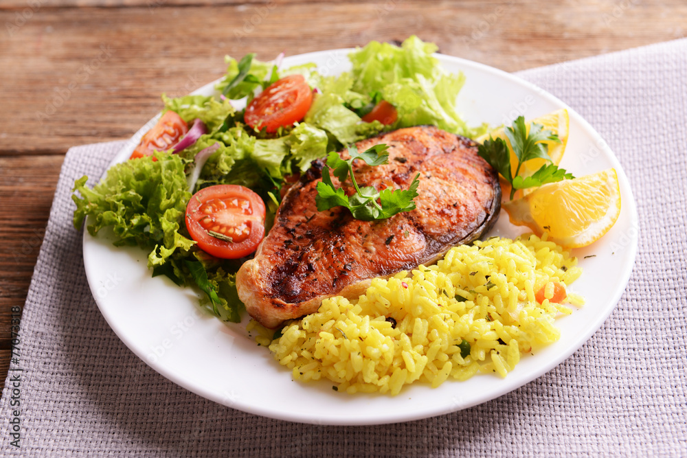 Tasty baked fish with rice on plate on table close-up Tasty baked fish with rice on plate on table close-up