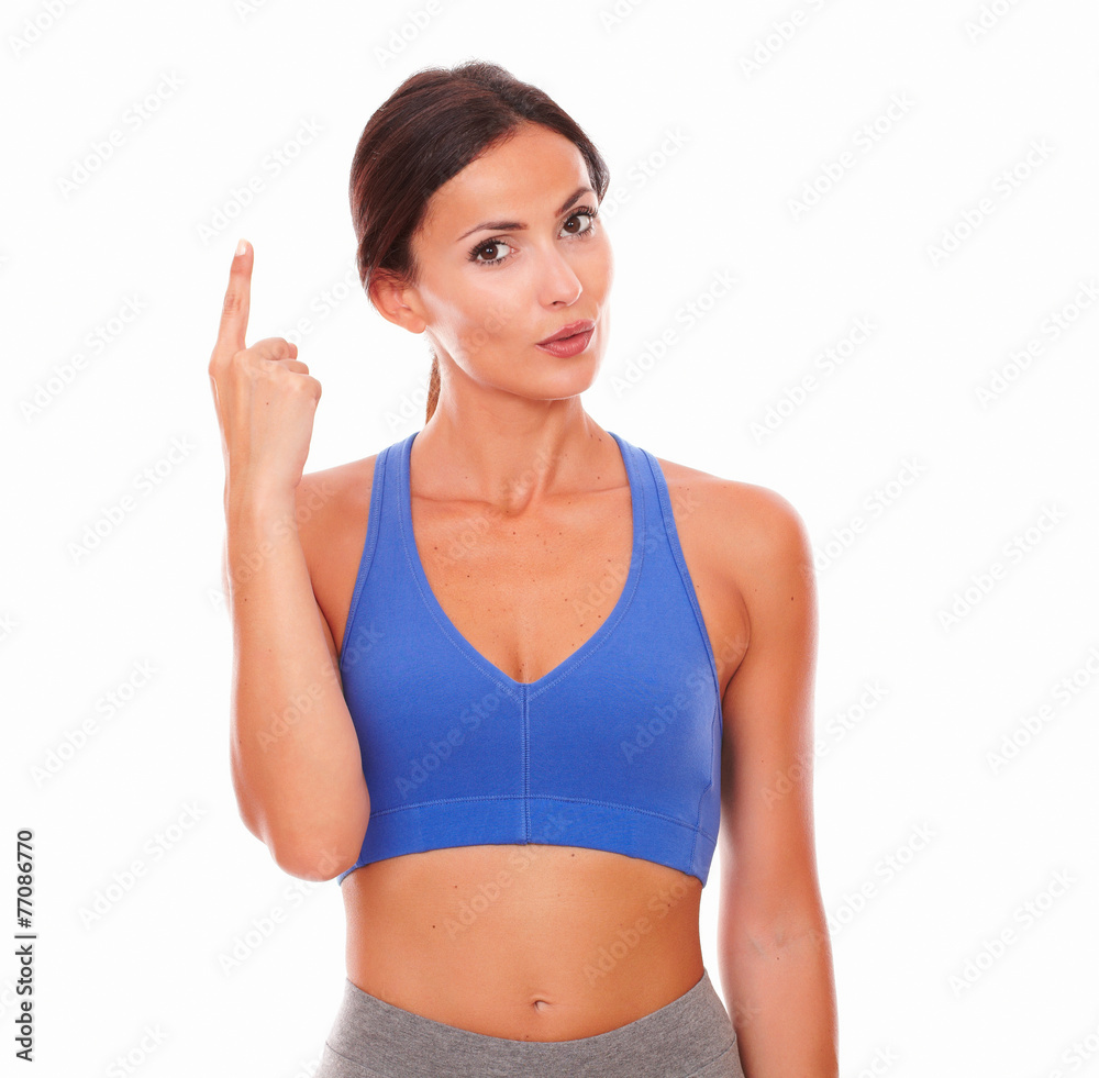 Slim lady in training clothing pointing up Slim lady in training clothing pointing up