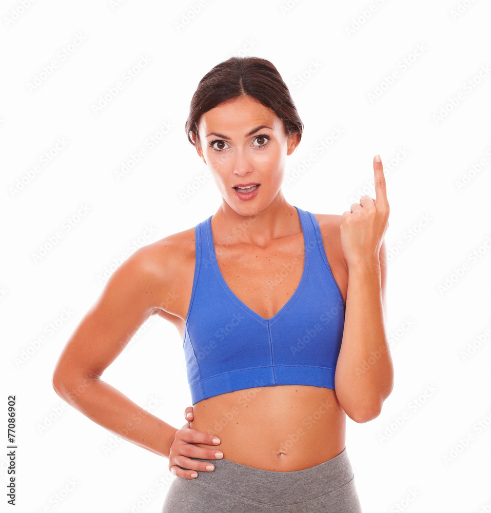 Fit lady in sport clothing pointing up Fit lady in sport clothing pointing up