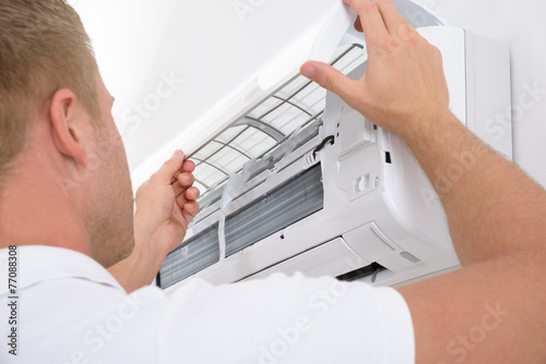 Man Adjusting Air Conditioning System photo