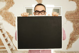 Man in glasses holding blank blackboard in hands