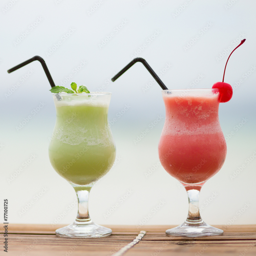 Two fresh fruit juices on a tropical beach Two fresh fruit juices on a tropical beach