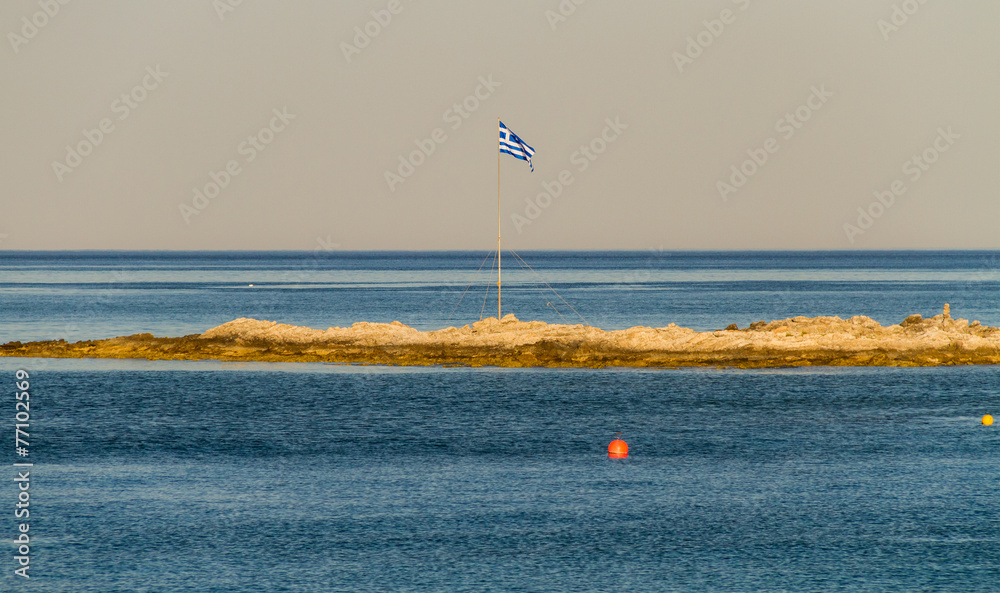 Greek flag on small piece of land in the sea