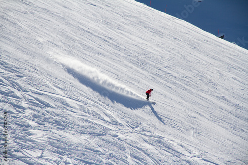 Skier going down the slope at ski resort.