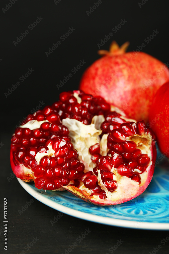Juicy ripe pomegranates on wooden table, on dark background Juicy ripe pomegranates on wooden table, on dark background