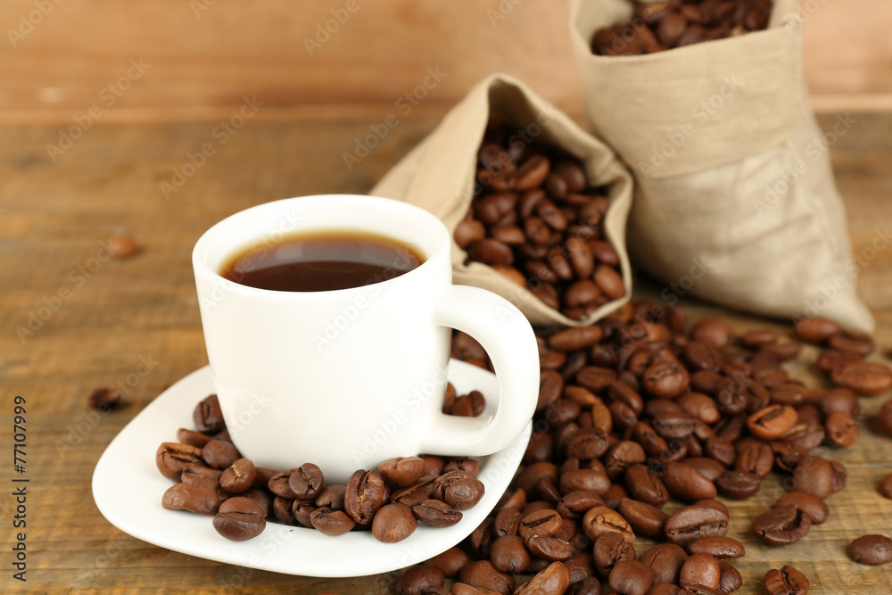 Cup of coffee with beans on rustic wooden background Cup of coffee with beans on rustic wooden background