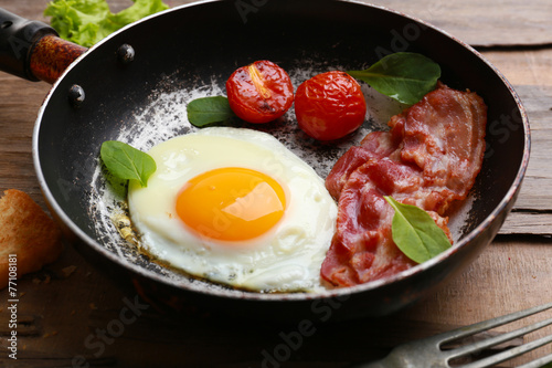 Bacon and eggs on rustic wooden planks background