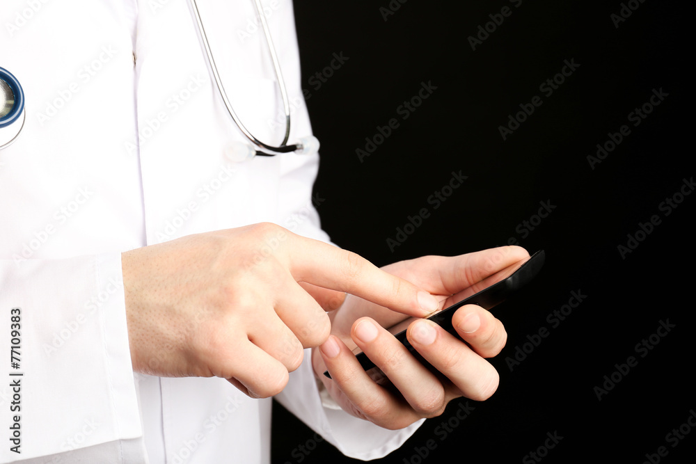 Doctor working with mobile phone on black background