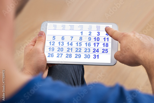 Man Looking At Calendar On Cellphone