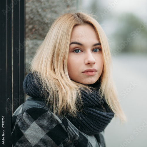 Art portrait of a young blonde woman in a in plaid jacket