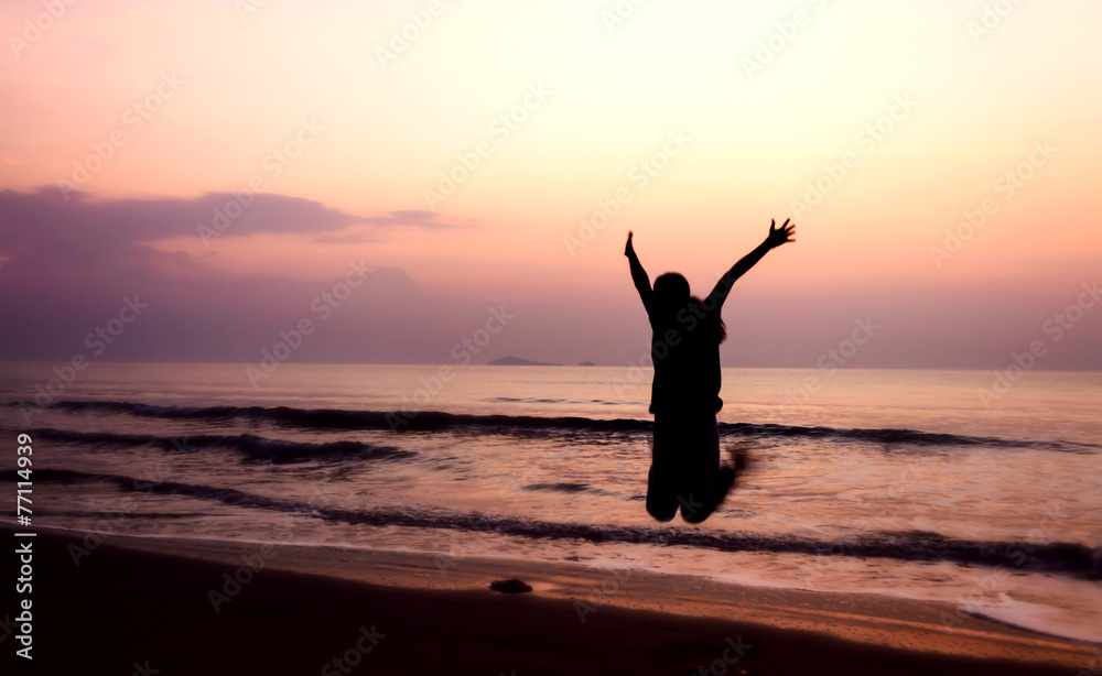 silhouette of woman jumping on the beach