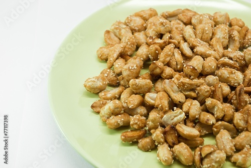crispy peanut with sesame in green plate on white background