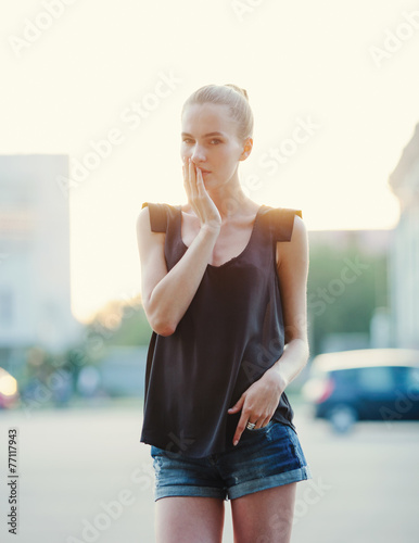 Emotive young beautiful woman posing on the street