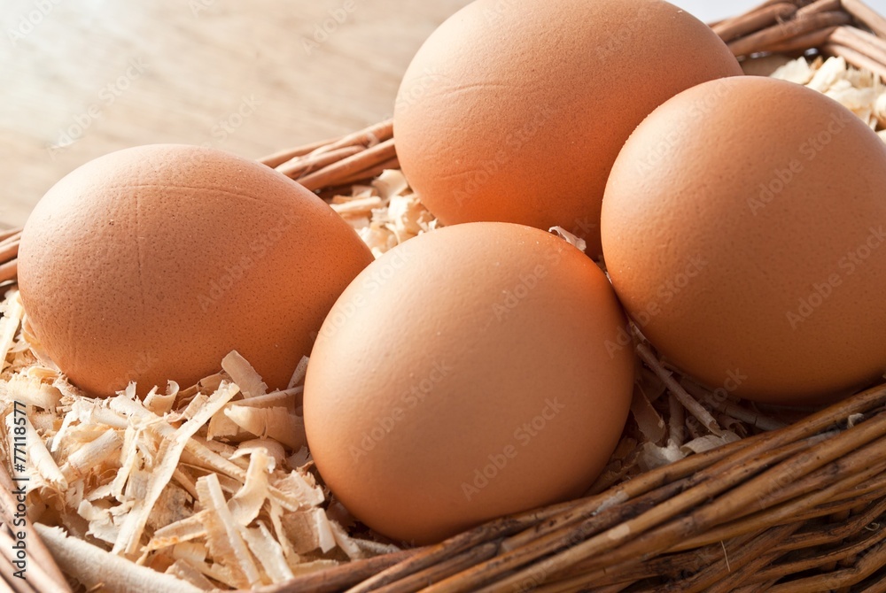 Egg on sawdust with old basket over on wooden background Egg on sawdust with old basket over on wooden background