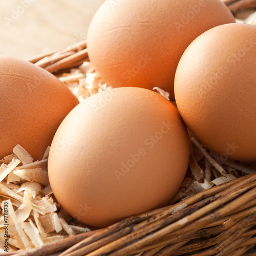Egg on sawdust with old basket is over on wooden background
