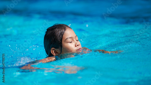 Cute girl with goggles in swimming pool