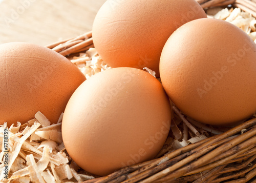 Egg on sawdust with old basket is over on wooden background