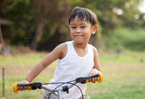 happy young asia boy riding a bike outdoors