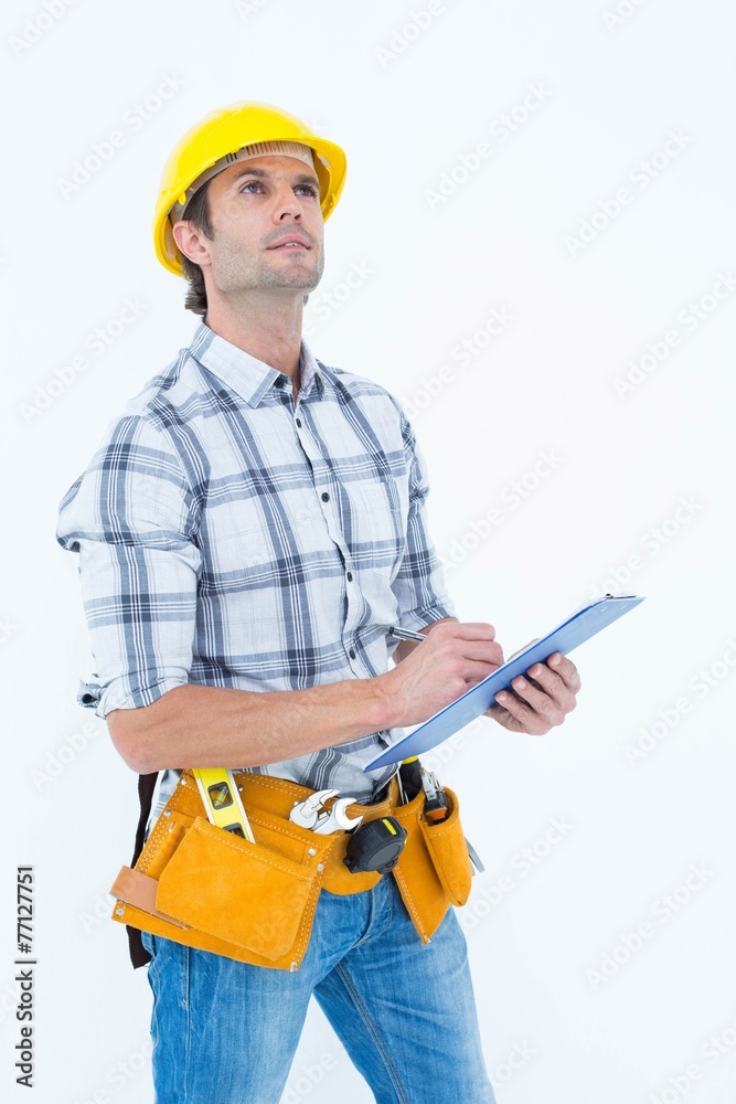 Handsome architect writing notes on clip board