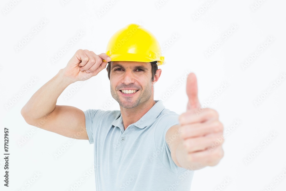 Architect wearing hardhat while showing thumbs up sign