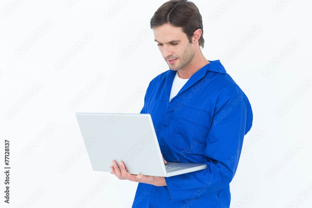 Mechanic using laptop over white background