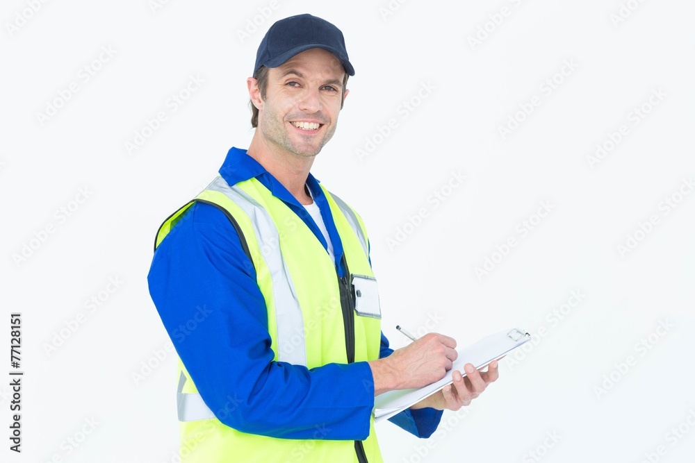 Handsome supervisor writing notes on clipboard Handsome supervisor writing notes on clipboard