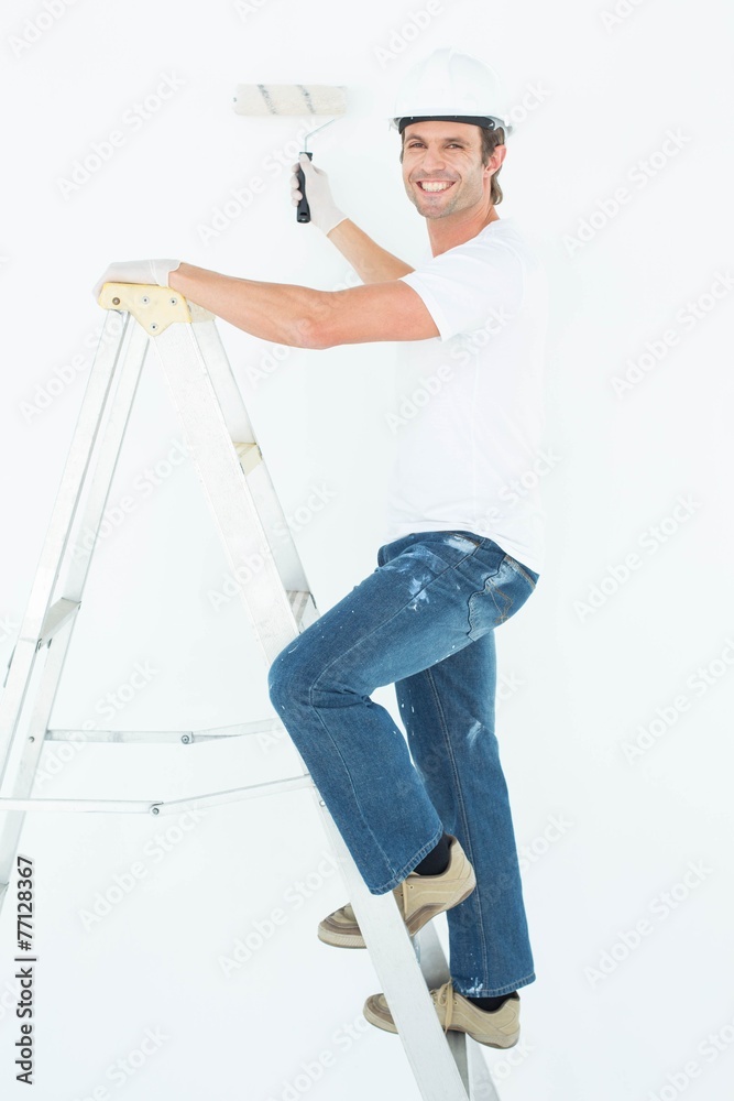 Portrait of man on ladder painting with roller Portrait of man on ladder painting with roller