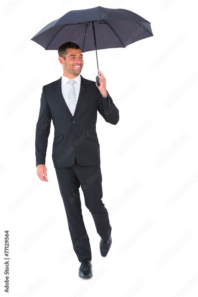Smiling businessman sheltering under black umbrella Smiling businessman sheltering under black umbrella