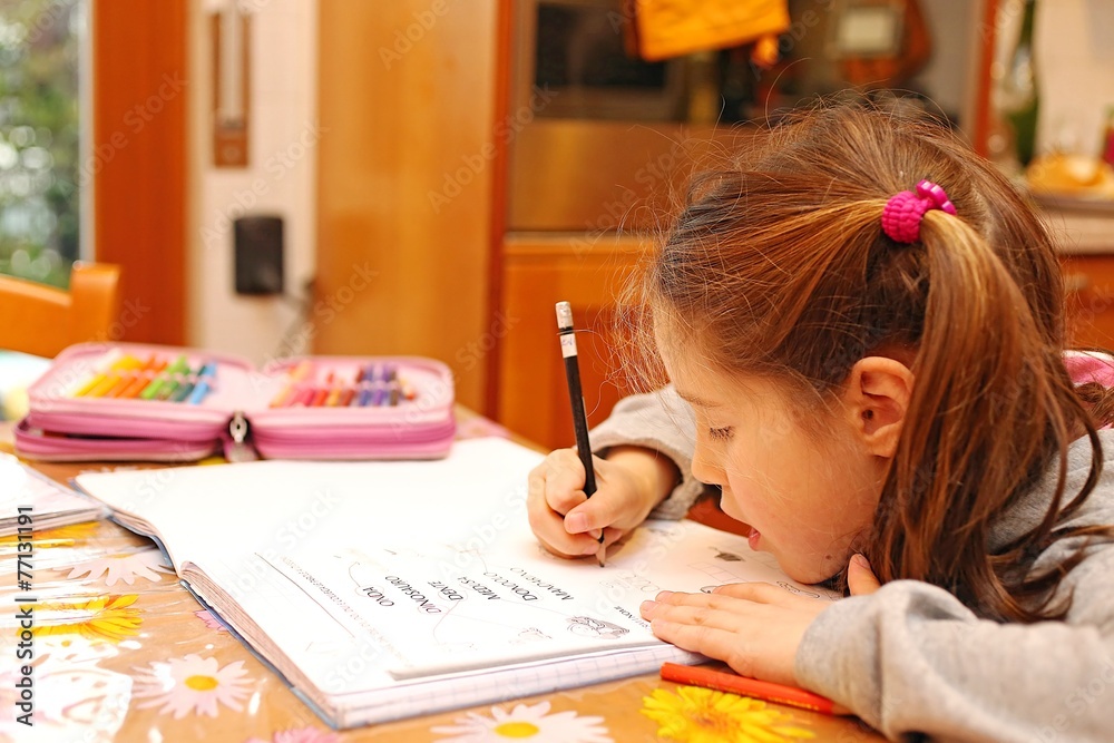 little girl writes the homework on notebook little girl writes the homework on notebook