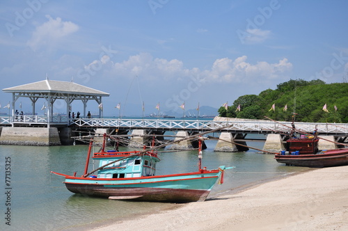 Thai fishing wooden boat and Asdang Bridge as a background.