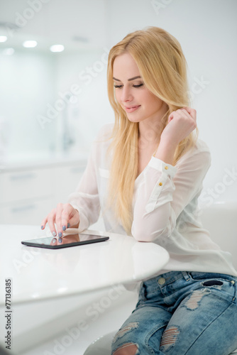 Blond Woman at the Table with Tablet Computer