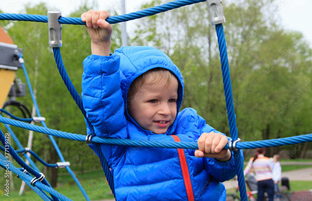 little boy climbing rope on the playground little boy climbing rope on the playground