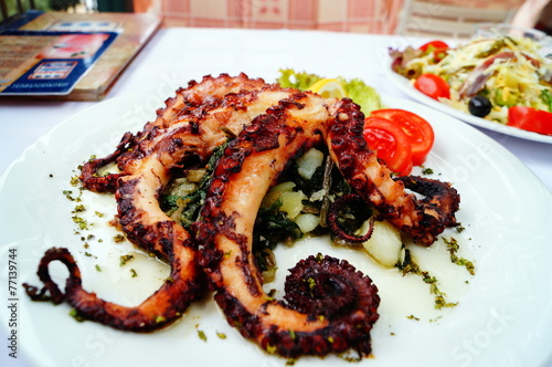 Gourmet dinner. Grilled octopus with vegetables