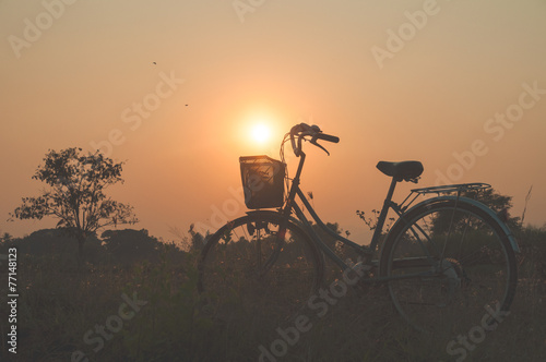 Bicycle with sun set background © guykantawan