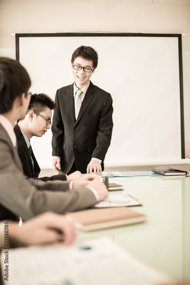 Businessman standing in front of colleagues during a meeting Businessman standing in front of colleagues during a meeting