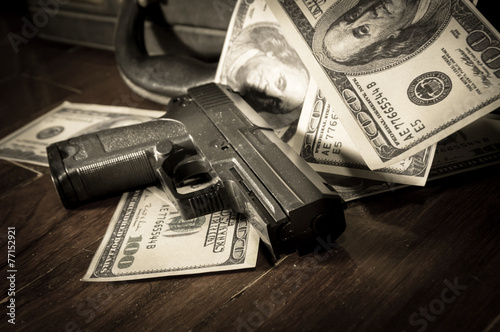 Sepia filtered of gun and dollar bills
